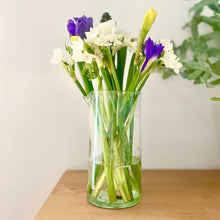 Clear glass vase with flowers on a wooden surface